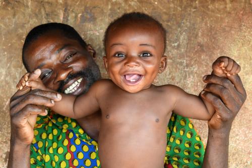 A baby smiles with his father in Cote D'Ivoire.
