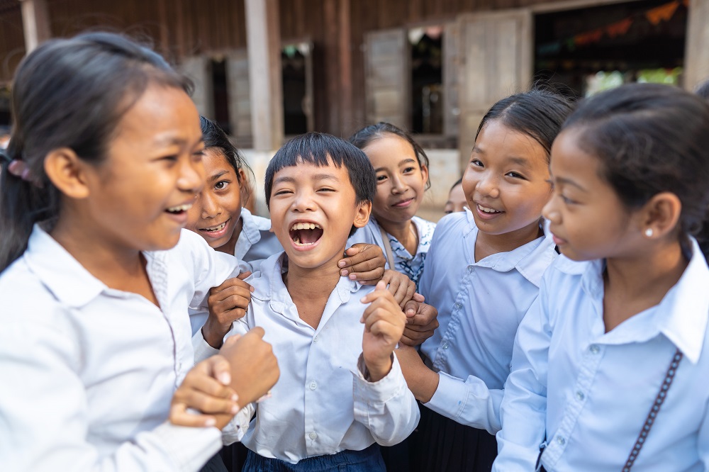 Children laugh outside their school in Cambodia.