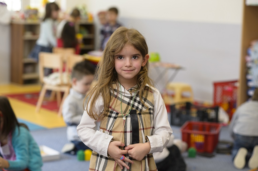 A young girl stands in her classroom in Montenegro. 