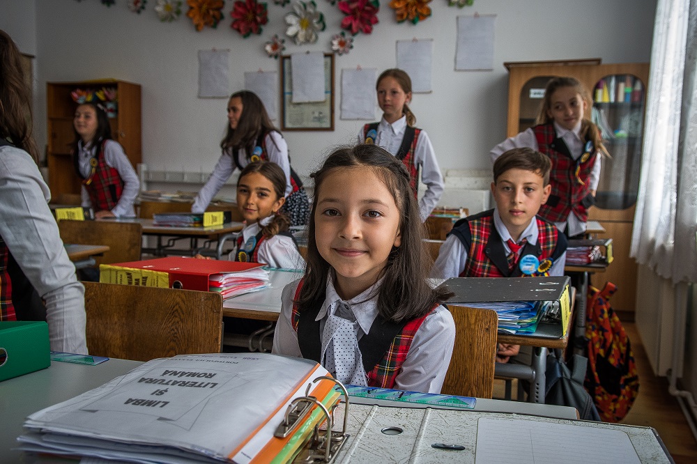Children sit in a classroom in Romania.