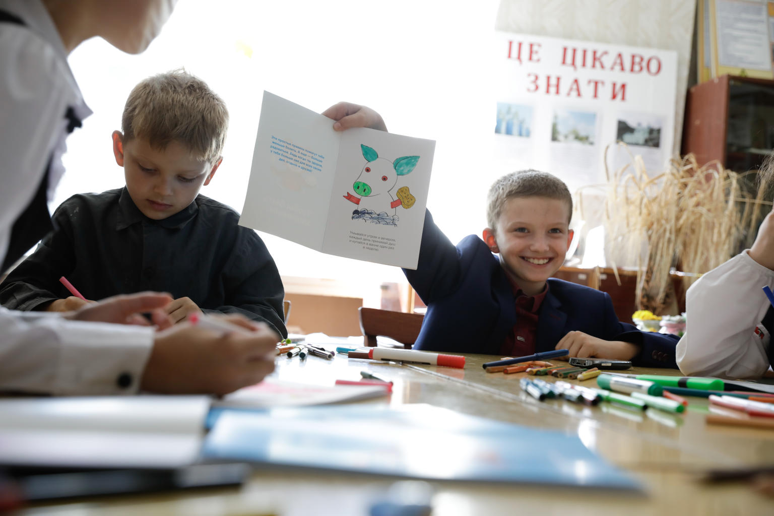 Children in Ukraine smile in the classroom.