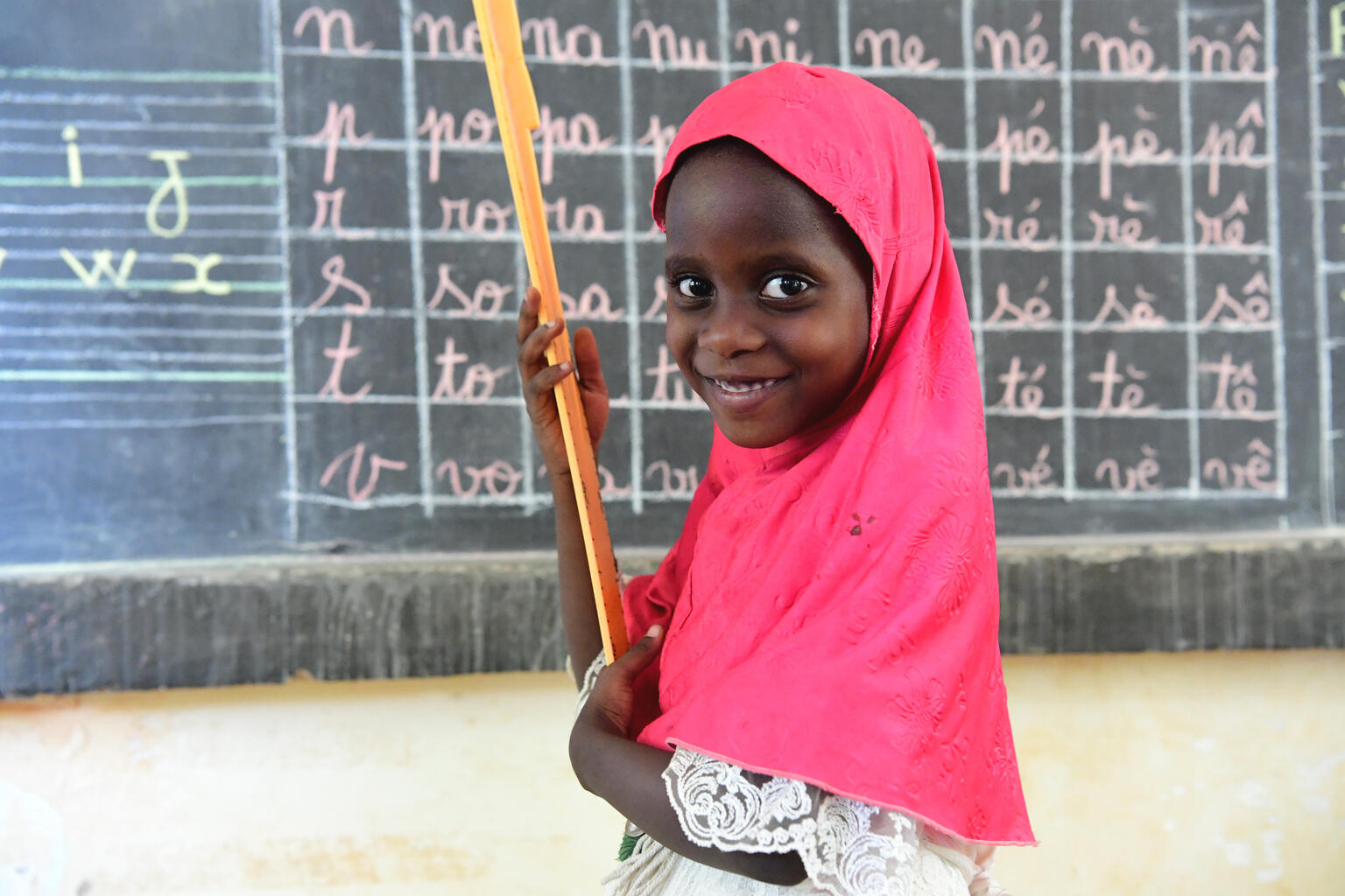 A girl in West Africa smiles at school.