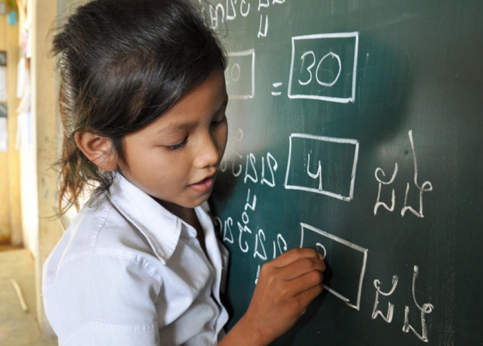 A child draws on a blackboard.