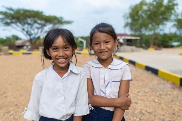 Girls in Cambodia smile at school.
